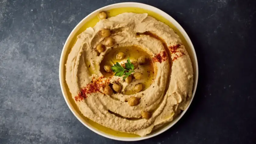 חומוס עבודת יד עם פול ושמן זית, מוגש בצלחת, מומלץ לטעום בחומוסייה בגליל.