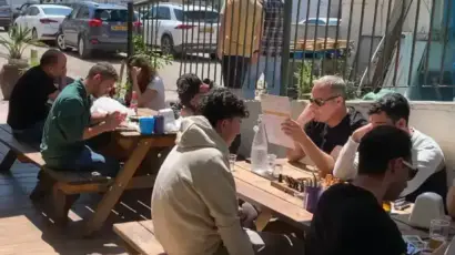 סועדים נהנים בחומוס הבוטקה, חומוסיה בגליל, באווירה נעימה תחת סוככים.