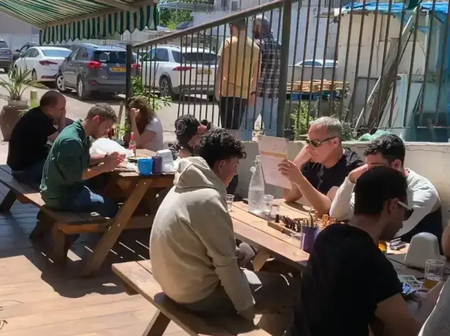 סועדים נהנים בחומוס הבוטקה, חומוסיה בגליל, באווירה נעימה תחת סוככים.