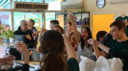 חגיגה בחומוס הבוטקה, אנשים שמחים מברכים עם חומוס ופול, אווירה נעימה בחומוסיה בצפון.